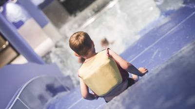 Kind rutscht Breitwasserrutsche hinunter