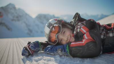 Kind auf Schnee liegend