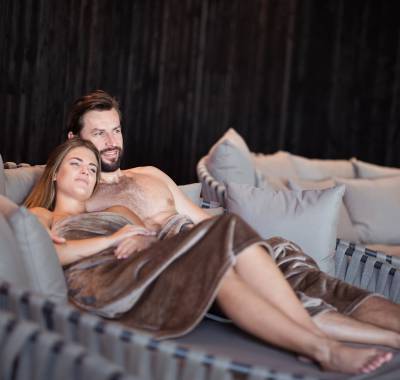 Paar liegt auf Ruheliegen im Wellnessbereich des A&L in Südtirol
