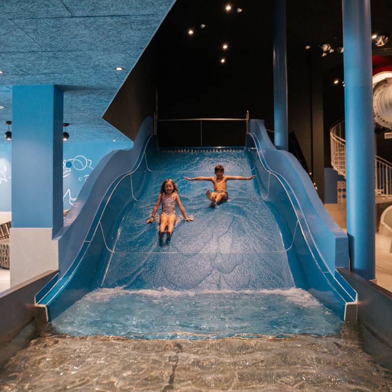 Zwei Kinder auf der Kinderrutsche im A&L Wellnessresort